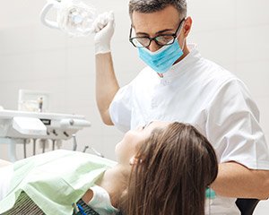 Dentist working with dental patient in exam room