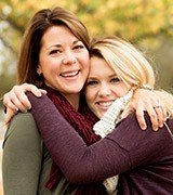 Mother and daughter hugging outdoors