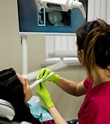 Dentist and patient looking at photos captured by intraoral camera