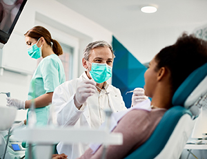 a dentist performing a dental checkup in Carrollton