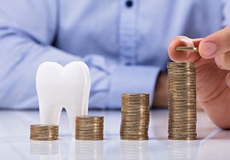 Tooth next to a pile of coins