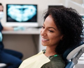 a patient smiling about the cost of tooth extractions