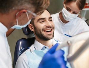 a patient smiling before undergoing tooth extractions