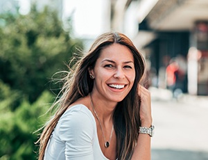 a smiling woman sitting outside