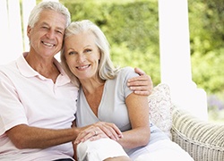 Older couple smiling together while sitting outside