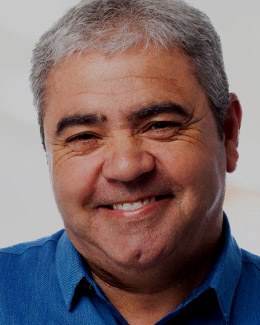 Older man smiling and wearing blue collared shirt