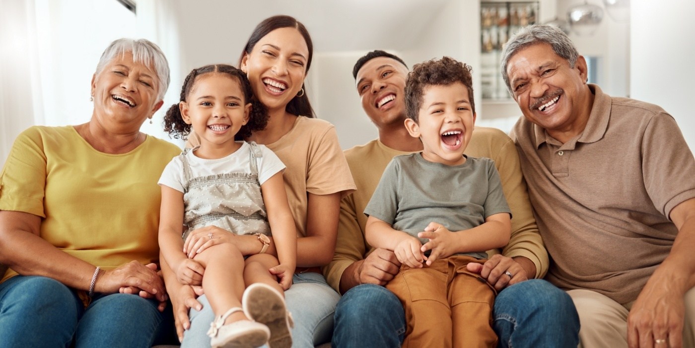 Three generations of a family smiling together outdoors