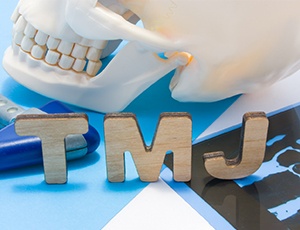 Model of skull with cardboard letters that say “TMJ”