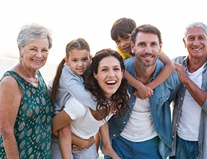 Happy family smiling on the beach after visiting their UnitedHealthcare dentist in Carrollton