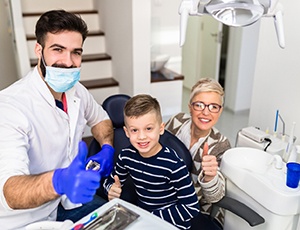 Mom and son visiting dentist and giving thumbs up