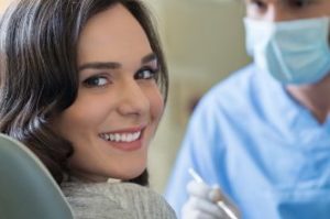 A smiling female patient in the dental chair