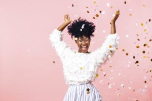 Smiling woman throwing glitter