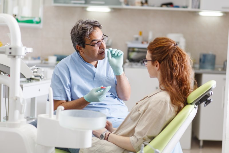 a male dentist in Plano talking with a female patient during an appointment