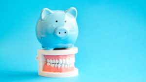 Blue piggy bank atop model teeth from Carrollton dentist