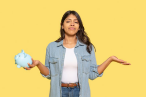 Woman holding a piggy bank and shrugging on yellow background